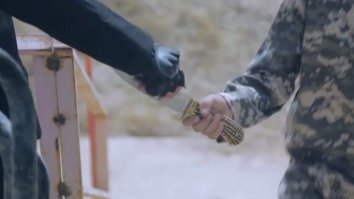 Screen shot from an ISIL video showing a militant giving a young boy a knife. Moments later in the video, the boy beheads an 'apostate'.