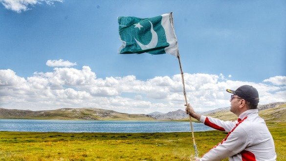A man waves the Pakistani flag near Deosai Lake in Skardu in September. [Alamgir Khan]