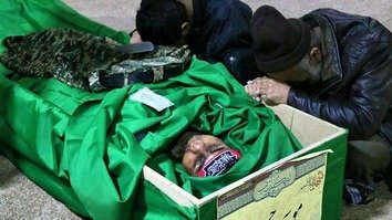 جعفرآباد میں ایک جنازے کے دوران دو شخص شام میں قتل ہو جانے والے فاطمیون ڈویژن کے ایک رکن کے لیے گریہ کر رہے ہیں۔ تجزیہ کاروں کے مطابق، شام میں لڑتے ہوئے مارے جانے والے افغان شعیہ اکثر ایران میں دفنائے جاتے ہیں۔