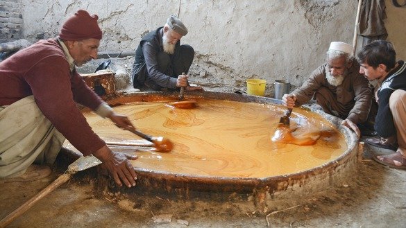 Farmers in Charsadda District cool down hot liquid gur in January into a soft solid. [Alamgir Khan]
