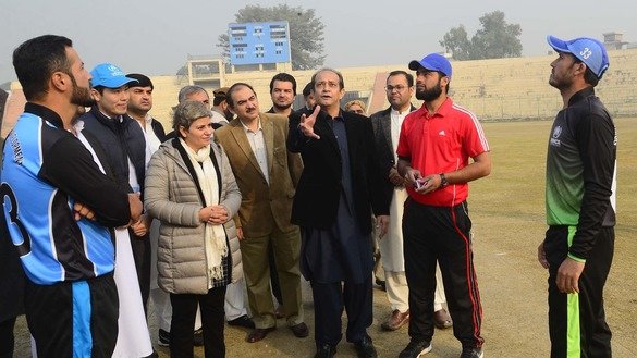 Commissioner for Afghan Refugees in KP Muhammad Abbas Khan takes part in a coin toss before the start of a cricket match in Peshawar December 5. [Shahbaz Butt]