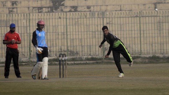 A player in the Afghan refugee league throws a ball in Peshawar December 5. [Shahbaz Butt]