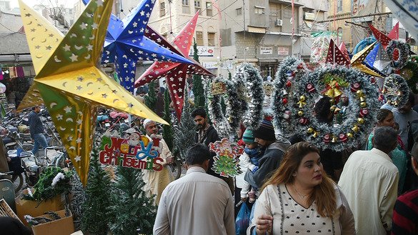 پاکستانی مسیحی افراد، 16 دسمبر کو کراچی میں کرسمس سے پہلے ایک بازار میں سجاوٹ کی اشیاء خرید رہے ہیں۔ ]آصف حسن/ اے ایف پی[
