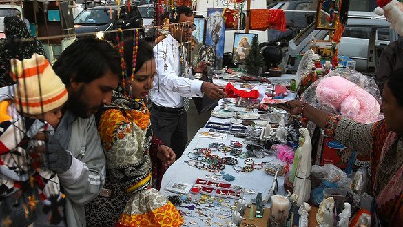مسیحی افراد کرسمس کی تقریبات سے پہلے، 18 دسمبر کو کراچی میں سڑک کے کنارے ایک دکان پر تحائف کو دیکھ رہے ہیں۔ ]آصف حسن/ اے ایف پی[