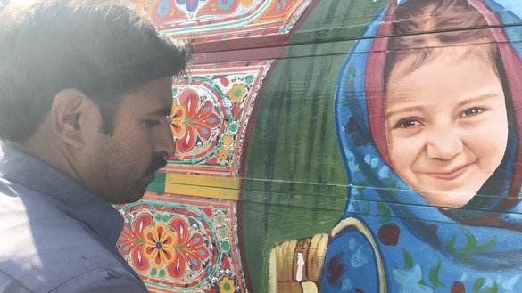 A truck artist in Peshawar gives the final touches to a painting of a schoolgirl December 10. [Nazar ul Islam]