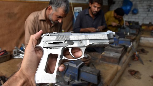 ایک بندوق ساز 15 نومبر کو پشاور میں ایک دکان پر مقامی طور پر تیار ہونے والا پستول دکھاتے ہوئے۔ [عدیل سعید]