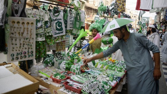A vendor in Peshawar offers a variety of merchandise for celebrating Independence Day. [Shahbaz Butt]