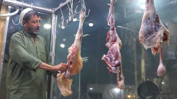 A restaurant employee in Peshawar September 1 cuts meat to make tikka karahi. [Alamgir Khan]