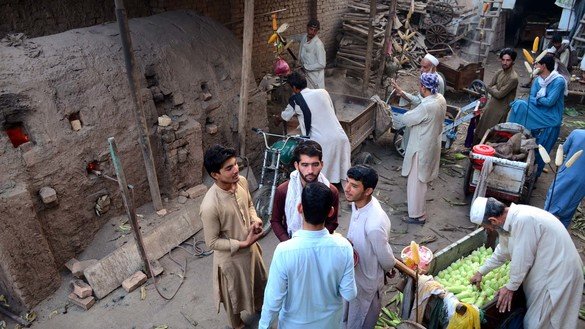 31 اکتوبر کو پشاور میں پھیری والے اپنے ٹھیلوں میں گرم ریت ڈالنے کے لیے قطار لگائے انتظار کرتے ہوئے۔ [عدیل سعید]