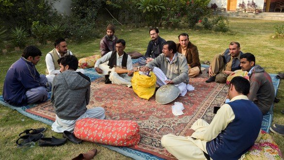 10 دسمبر کو لی گئی اس تصویر میں اختر گل (درمیان میں بائیں جانب) پشاور میں ایک روایتی آلہٴ موسیقی رباب بجا رہے ہیں۔ [عبدالمجید /اے ایف پی]