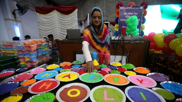 پشاور میں 10 مارچ کو ایک خاتون رنگوں سے "ہولی مبارک" لکھ رہی ہے۔ [شہباز بٹ]