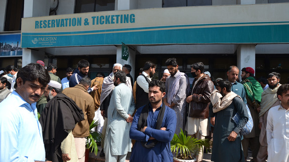 Pakistani expatriates March 15 gather outside the Pakistan International Airlines ticket office in  Peshawar Saddar to reschedule their flights to Saudi Arabia and other Gulf countries. Pakistan ordered all international flights to use only three airports -- Karachi, Lahore and Islamabad -- March 15 to 31 in response to the coronavirus pandemic. [Shahbaz Butt]