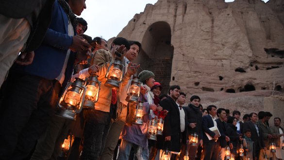 Bearing lamps, local residents and activists during a 20th anniversary remembrance ceremony on March 9 stand at the base of the cliff where the Salsal Buddha once stood. The Taliban destroyed the Buddhas of Bamiyan in March 2001. [Wakil Kohsar/AFP]