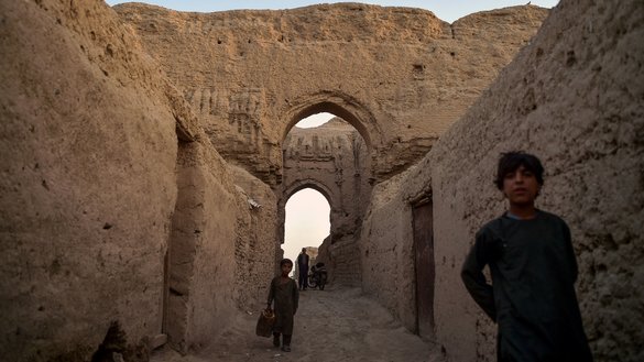 اندرونِ ملک بے گھر ہو جانے والے افغان بچے، 27 مارچ کو قلعہ کوہنا کے تاریخی مقام پر، ایک محل کے کھنڈرات کے درمیان چل رہے ہیں، جہاں وہ اپنے اہلِ خاندان کے ساتھ قیام پذیر ہیں۔ [وکیل کوہسار/ اے ایف پی]