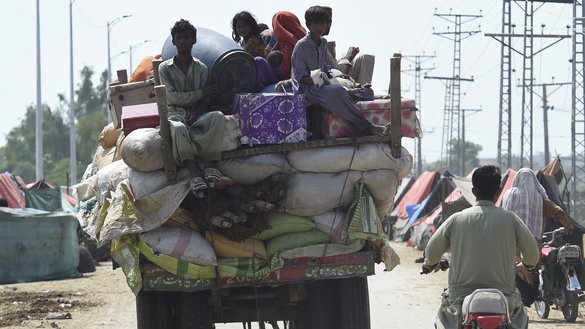 Displaced survivors arrive on a tractor with their belongings at a makeshift camp after fleeing from their flood-hit homes following heavy monsoon rains in Sukkur, Sindh province, on August 29. [Asif Hassan/AFP]