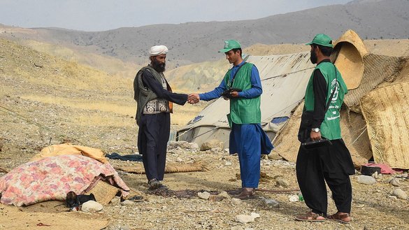 A census official holding a tablet shakes hands with a Marri tribesman living in the remote mountainous area of Mawand as part of a national census in Kohlu district, Balochistan province, southwest Pakistan. [Banaras Khan/AFP]