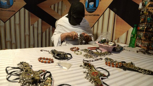 A woman crafts jewellery at the Hunar Mela May 9. [Shahbaz Butt]