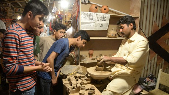 A potter makes earthenware toys at the Hunar Mela May 9. [Shahbaz Butt]