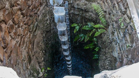 A drive shaft connects the vertical cog to a larger wheel, over which a chain of buckets is draped. The bucket chain descends into a well, stream or other water source to fetch the water. [Alamgir Khan]