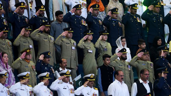 Pakistani military officers salute as they hear the national anthem after hoisting the country's flag to celebrate Independence Day in Islamabad August 14. [Aamir Qureshi/AFP]