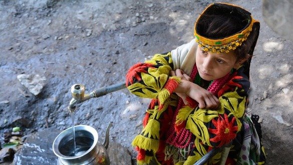 ایک کیلاش لڑکی اپنے برتن میں چشمے کا پانی بھرتے ہوئے۔ [عالمگیر خان]