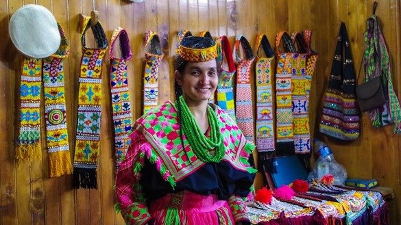 ایک کیلاش خاتون اپنی دکان میں روایتی لباس فروخت کرتے ہوئے۔ [عالمگیر خان]