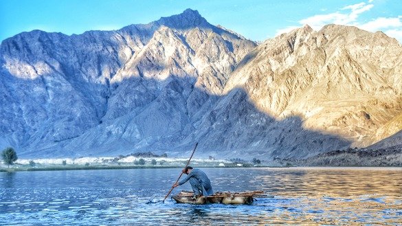ستمبر میں ضلع شیگار، گلگت بلتستان میں ایک شخص اندھی جھیل میں ایک دیسی ساختہ کشتی چلا رہا ہے۔ [عالمگیر خان]