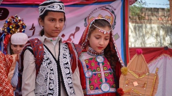 لڑکوں اور لڑکیوں کے روایتی لباسوں میں ملبوس اسکولوں کی قبائلی بچیوں کو مہمند سپورٹس یوتھ اینڈ کلچرل فیسٹیول کے دوران دکھایا گیا ہے۔ [عالمگیر خان]