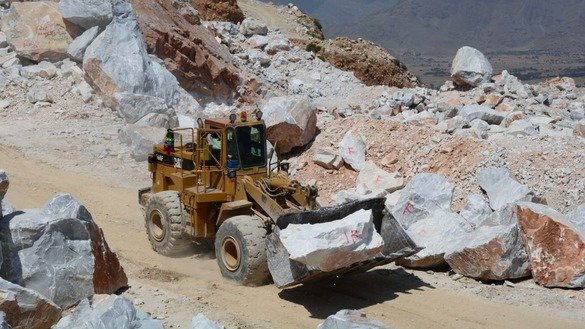 A loader hauls marble to a nearby truck in Mohmand Agency in May. [Alamgir Khan]