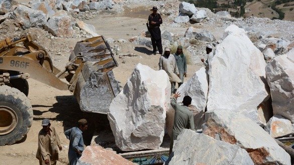 Workers load marble onto a truck in May in Mohmand Agency. [Alamgir Khan]