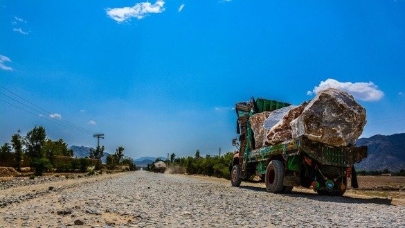 Trucks carry marble from a mountain to a factory in Mohmand Agency in May. [Alamgir Khan]