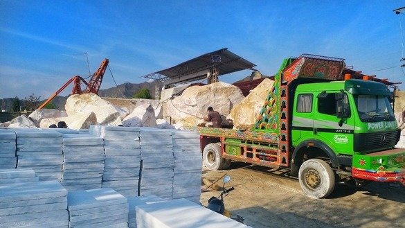 Workers unload a truck at a marble factory in Mohmand Agency in May. [Alamgir Khan]