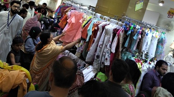 10 جون کو راولپنڈی میں عید الفطر سے قبل ایک خاتون لڑکیوں کے کپڑے خرید رہی ہے۔ [سیّد عبدالباسط]