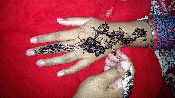 A woman has her hand painted with henna in Islamabad on June 12 ahead of Eid ul Fitr. [Syed Abdul Basit]