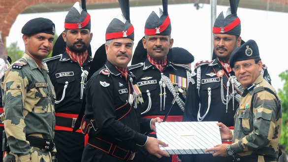 Pakistani Wing Commander Bilal (third from left) presents sweets to Indian Border Security Force Commandant Sudeep (right) during a ceremony to celebrate Pakistan's Independence Day at the India-Pakistan Wagah border post August 14. [Narinder Nanu/AFP]
