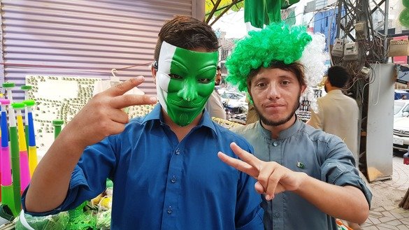 Two residents of Peshawar purchase different costumes to celebrate Independence Day August 14. [Danish Yousafzai]