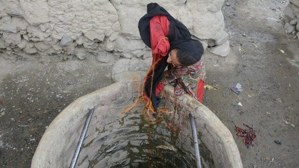 ضلع مہمند کی تحصیل بیزائی میں جولائی میں ایک لڑکی گہرے کنویں میں سے پانی نکالتے ہوئے۔ [عالمگیر خان]