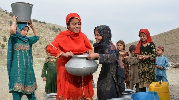 ضلع مہمند کی تحصیل بیزائی میں جولائی میں لڑکیاں پانی کے برتن لے جاتے ہوئے۔ [عالمگیر خان]