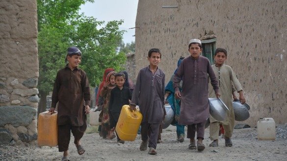 ضلع مہمند کی تحصیل بیزائی میں جولائی میں بچے پانی کے خالی برتن بھرنے کے لیے لے جاتے ہوئے۔ [عالمگیر خان]