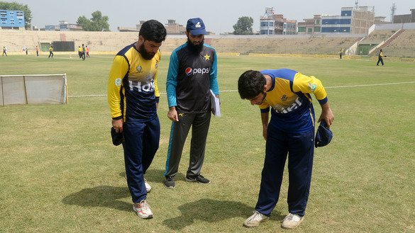 Captains of two cricket teams examine the result of a pre-match coin toss in Peshawar August 31. [Shahbaz Butt]