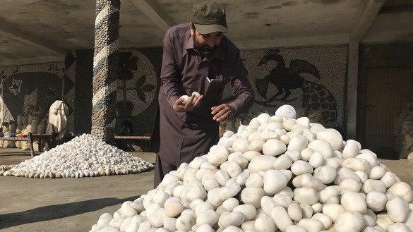The owner of a stone business picks out a variety of stones in Charsadda District. Khyber Pakhtunkhwa, November 8. [Nazar ul Islam]