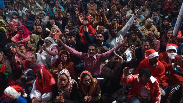 Christians attend a candlelight carol service during a Christmas celebration in Lahore December 19. [Arif Ali/AFP]