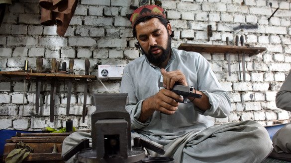 An artisan gunsmith works on a pistol at an arms manufacturing unit in Peshawar, Khyber Pakhtunkhwa, on November 15, 2018. [Adeel Saeed]