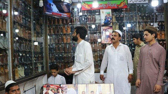 Customers select traditional chappal in a store in Peshawar on May 24. [Alamgir Khan]