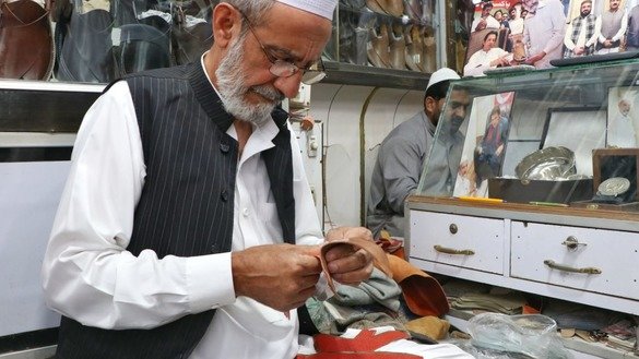 A shoemaker in Peshawar makes handmade shoes on May 24. [Alamgir Khan]