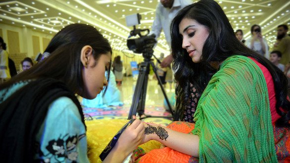 Women put henna on their hands June 3 in Peshawar to prepare for Eid ul Fitr. [Shahbaz Butt]