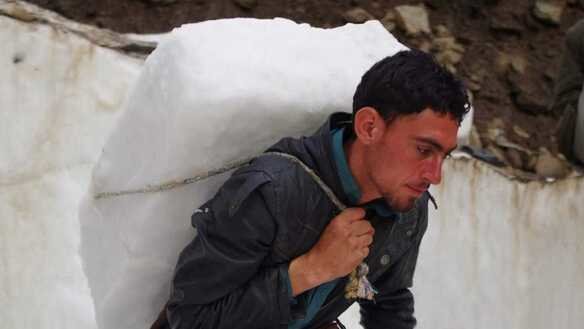 چترال کا ایک رہائشی یکم جولائی کو گلیشیئر سے برف لے جا رہا ہے۔ [عالمگیر خان]