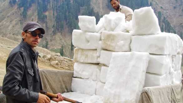 Chitral truck drivers load blocks of glacier ice on July 1. [Alamgir Khan]
