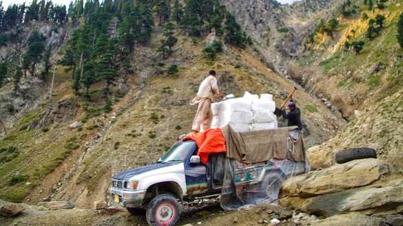 چترال کے شہری یکم جولائی کو گلیشیئر کی برف کی پہاڑی چوٹی سے چترال کے بازار میں لے جا رہے ہیں۔ [عالمگیر خان]
