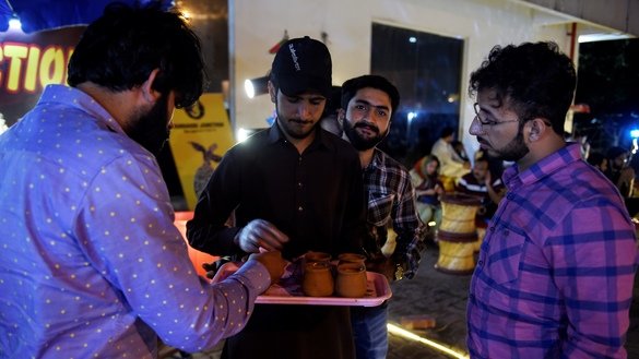 A waiter serves tandoori tea in clay pots to customers in Islamabad. [Farooq Naeem/AFP]
